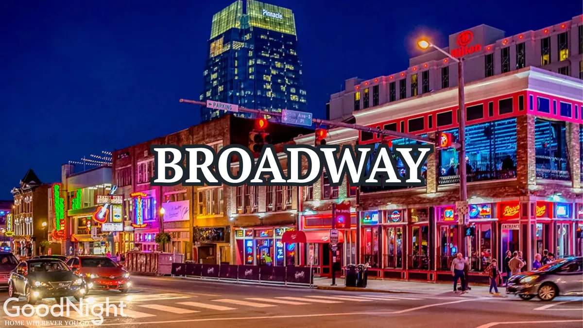 A lively Nashville street scene with neon signs illuminating busy sidewalks, crowds of people enjoying the nightlife, and the city skyline in the background. The atmosphere is electric, capturing the energy and excitement of the famous Broadway area known for live music and honky-tonk bars.
